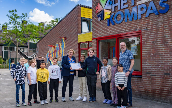 Alien Alberts (midden) van Comité 40-45 Hoorn met de leeerlingenraad van Het Kompas. Rechts directeur Jaap Muurling (foto: Benno Ellerbroek)