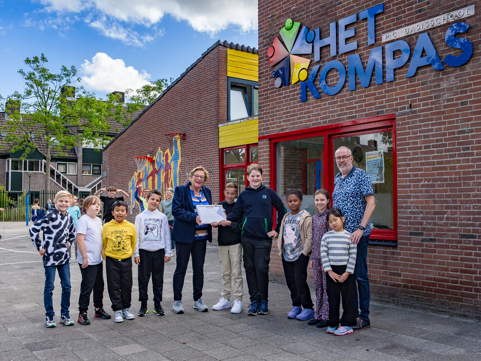 Alien Alberts (midden) van Comité 40-45 Hoorn met de leeerlingenraad van Het Kompas. Rechts directeur Jaap Muurling (foto: Benno Ellerbroek)